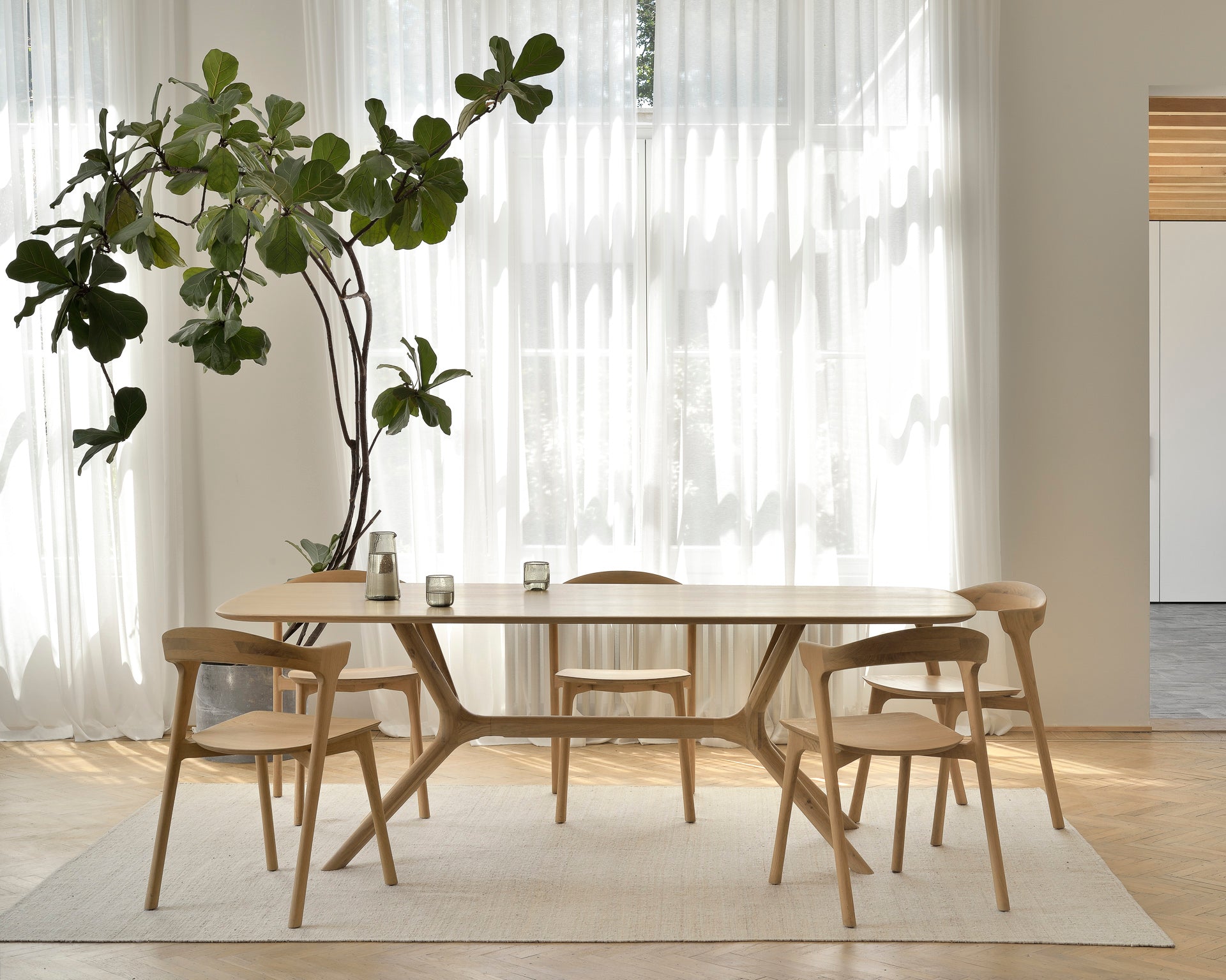 A lifestyle shot of a dining room featuring Ethnicraft solid wood furniture.