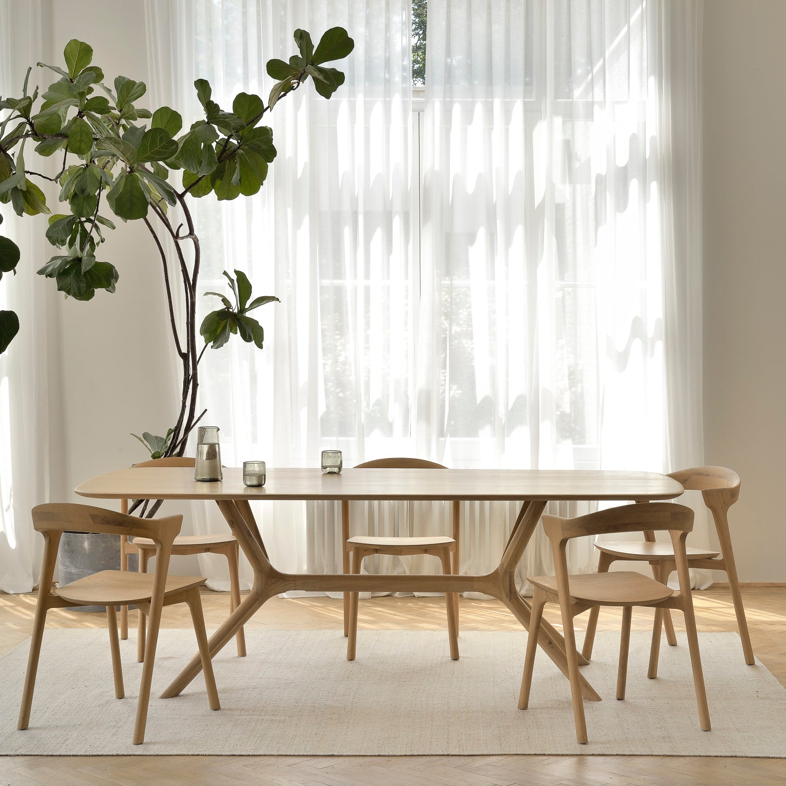 A lifestyle shot of a dining room featuring Ethnicraft solid wood furniture.