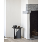 The Geometric Side Table from Ethnicraft in a family area near a fireplace.
