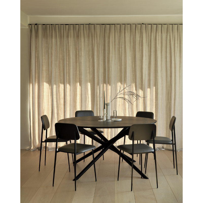 The Mikado round dining table, designed by Alain van Havre, has been one of our most recognizable designs for years. For its round version, we kept the same eye-catching construction but aimed for a visually lighter design. In an exercise of balance and stability, the legs are thinner and more refined, with round edges to fit the solid oak dining table's new shape.