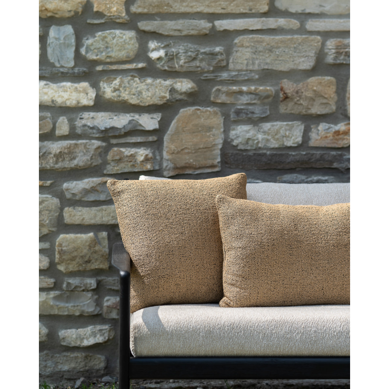 The Nomad Square Outdoor Cushion from Ethnicraft on a sofa in a lifestyle photograph.