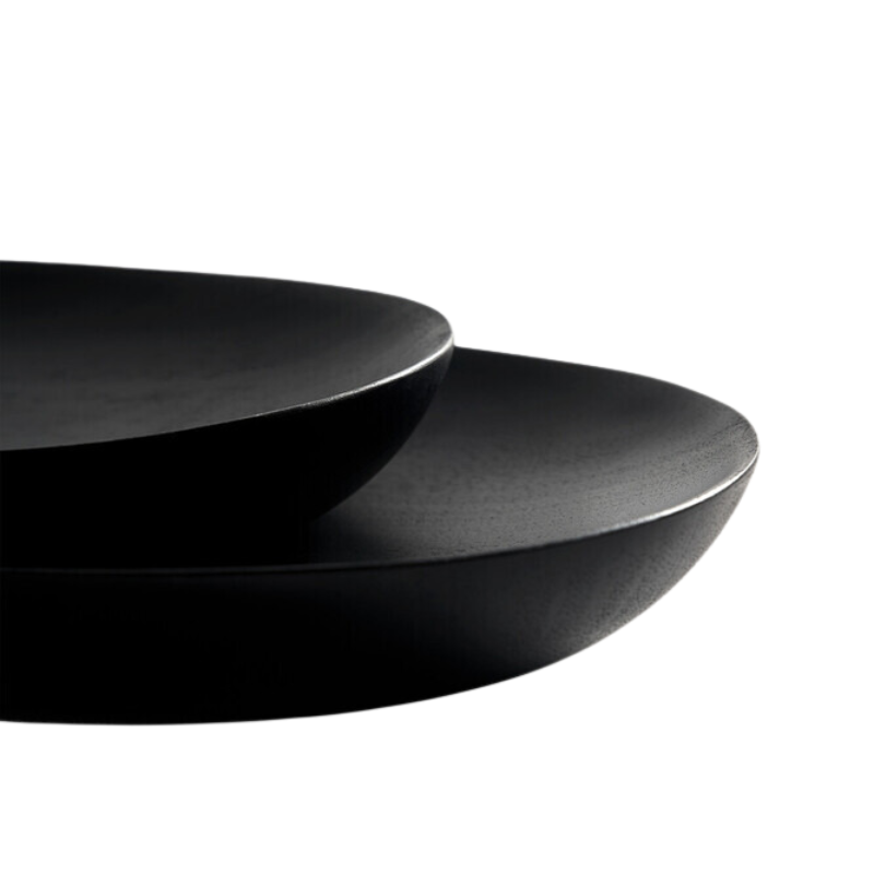 The Thin Oval Boards Set from Ethnicraft in black mahogany in a detailed photograph showing the solid wood texture.