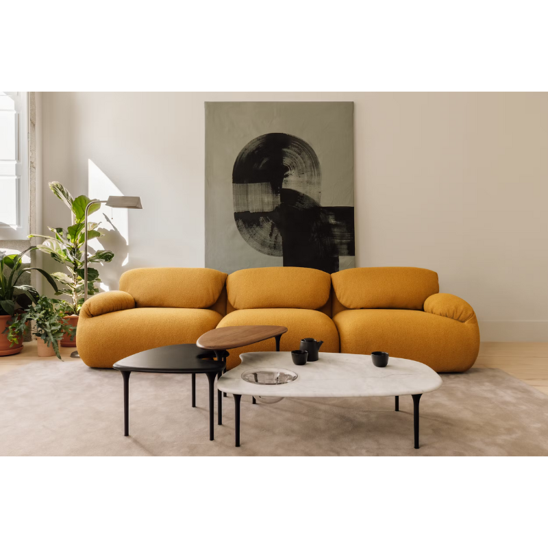 The low carrara marble table with bowl, mid black and high walnut Cyclade Tables from Herman Miller in a living space.