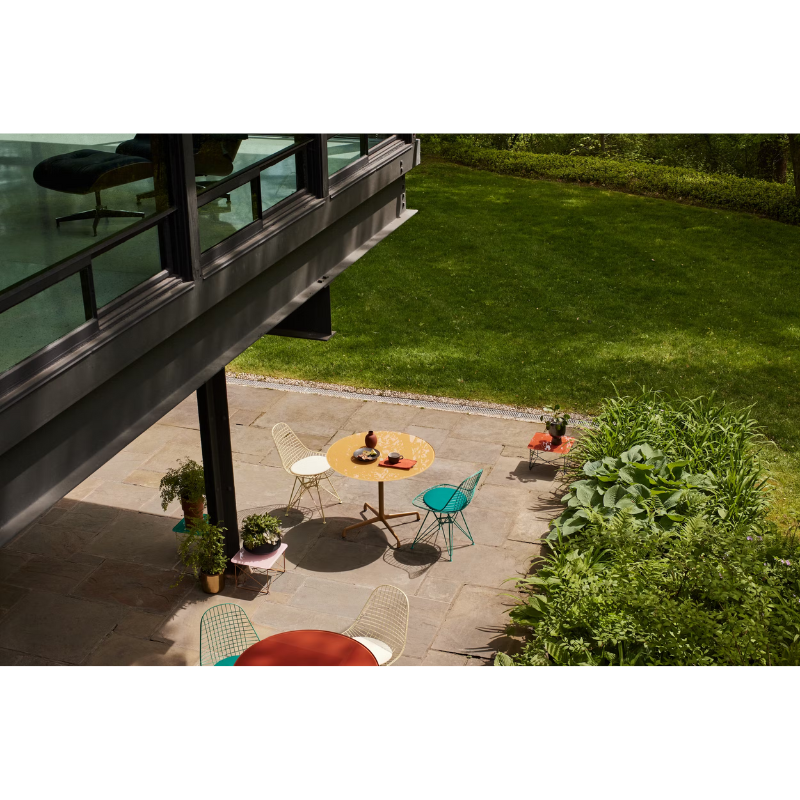 The Eames Dining Table from Herman Miller, designed by Herman Miller x Hay in a courtyard.