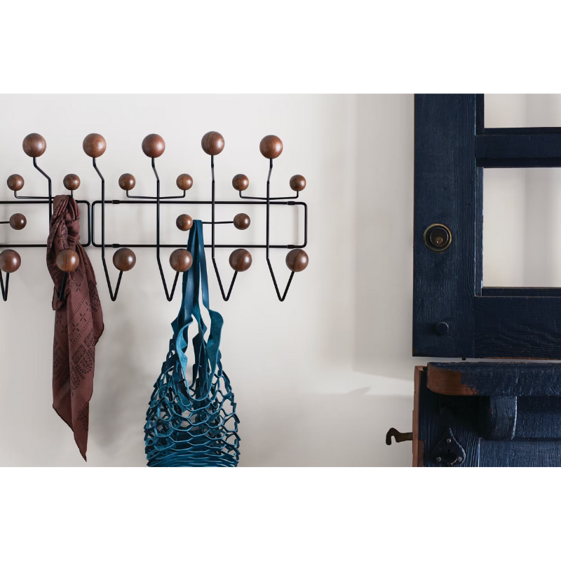 The Eames Hang-It-All from Herman Miller in a hallway, next to a door.