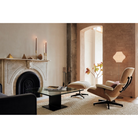 The Eames Lounge Chair and Ottoman from Herman Miller in a room with a fire place.