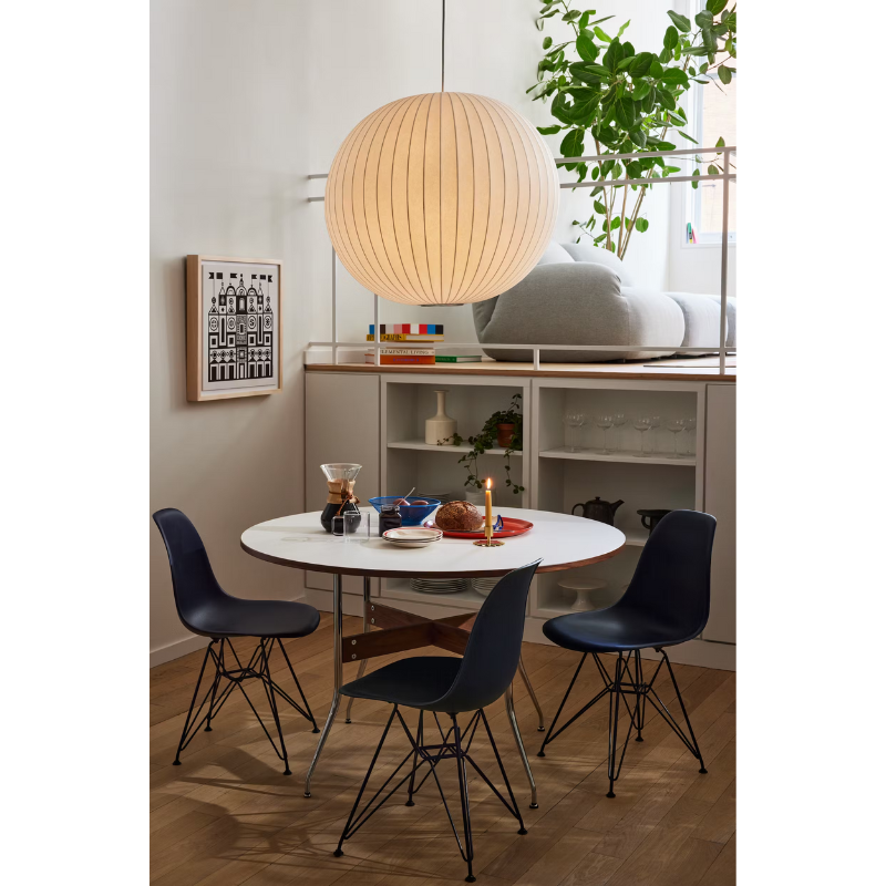 The Eames Molded Plastic Side Chair from Herman Miller designed by Herman Miller x HAY around a dining table.