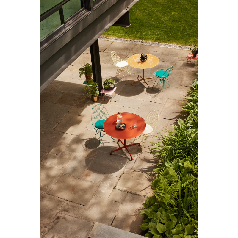 The Eames Wire Chair from Herman Miller, designed by Herman Miller x HAY in an outdoor lounge space.