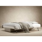 The Osvald Sofa Bed from Innovation Living with phobos latte 586 upholstery setup as a bed with sheets, pillows and a topper.