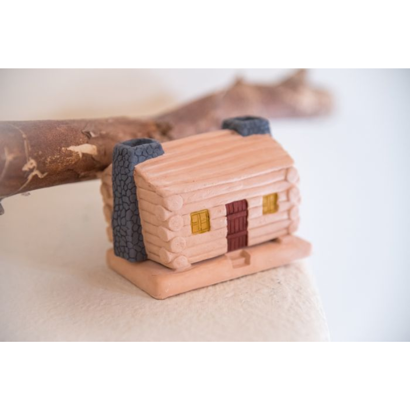 The Log Cabin Incense Burner from Inscents from a higher angle in a living room lifestyle shot.