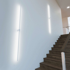 The Z-Bar Wall Sconce from Koncept lighting up a staircase in a hallway.