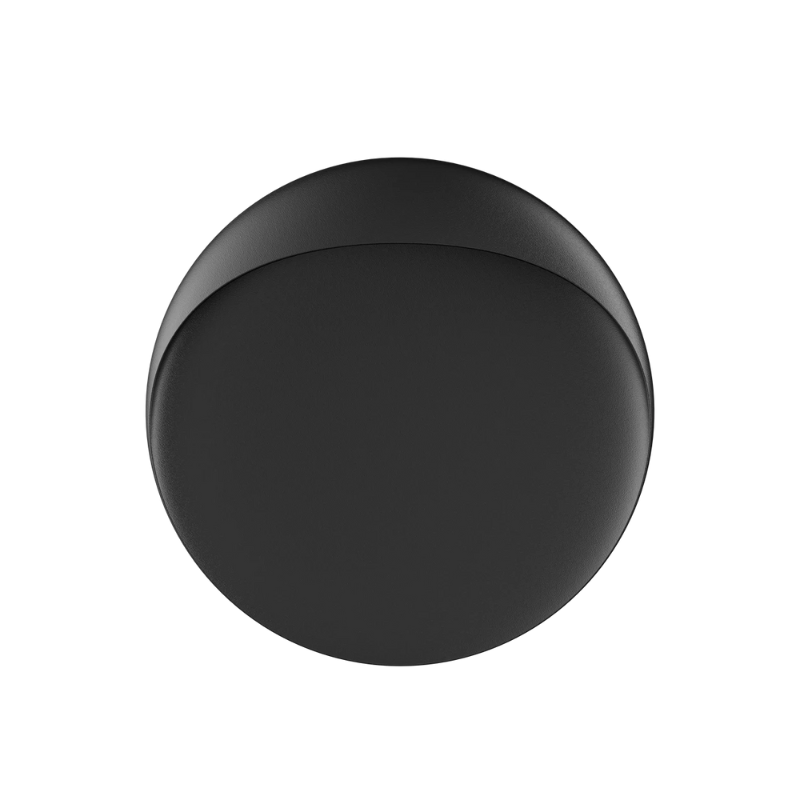 The Flindt Wall is distinguished by a light egress from an opening in the top that emits light down the front of the fixture, creating a subtle, glowing ring of reflected light on the transition between the concave and convex shapes. The oval shape is lifted off the mounting surface, giving the fixture a floating appearance.