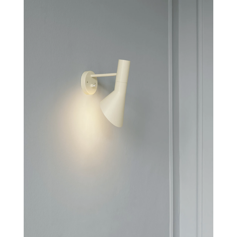 The AJ Wall Lamp was among the iconic lighting designs created by Aarne Jacobsen in 1960 for the SAS Royal Hotel. The lighting fixture emits downward directed light. The angle of the shade can be adjusted to optimize light distribution and the shade is painted white on the inside to ensure a soft comfortable light.