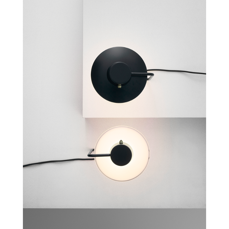 The AJ Oxford Table Lamp emits a pleasant downwardly directed light, which harmoniously illuminates the surface below it through the soft transparency of its triple-layered hand-blown opal glass. In the variant without the top metal shade, the milky opal-glass shade provides further glow to form an alluring halo around the fixture.