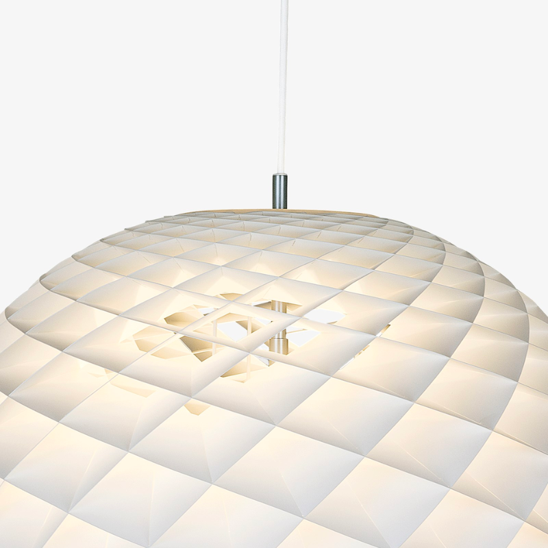 The Patera pendant is a glowing sphere built up of small diamond-shaped cells. Each cell is carefully designed to capture light and to shield the light source from the viewing angles above 45 degrees. Each cell glows. Below 45 degrees, the fields are open to direct light downwards. A small amount of light is also sent upwards to illuminate the ceiling. Designed by Danish designer Øivind Slaatto who took inspiration from the Fibonacci spiral.