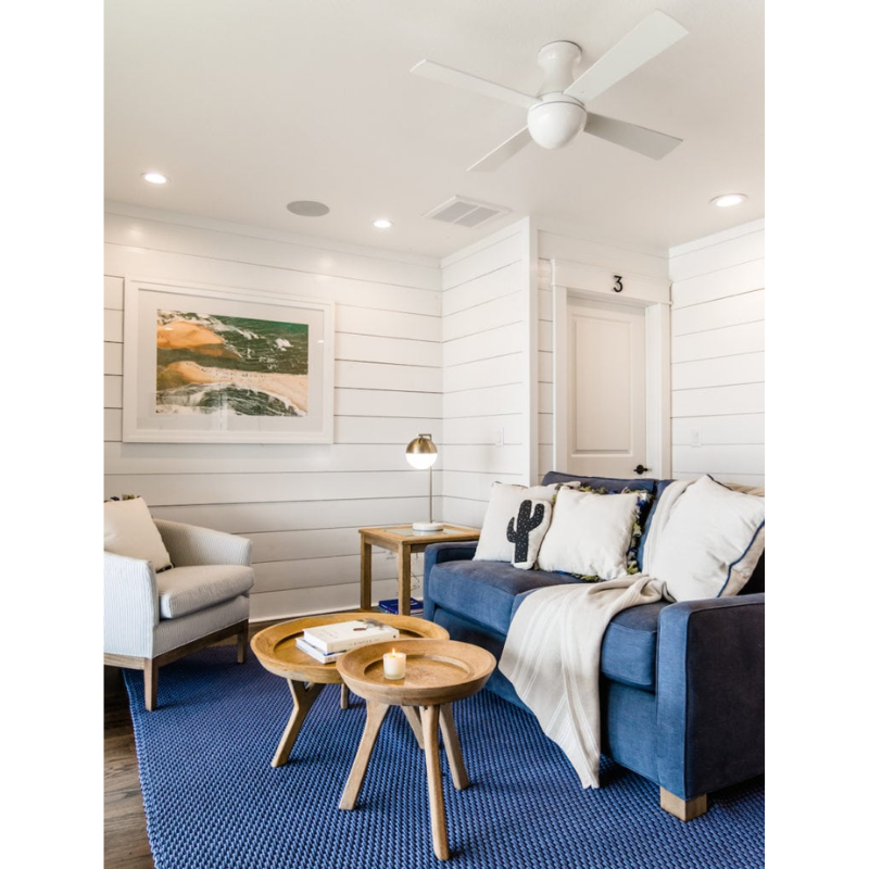 The Ball Flush ceiling fan from Modern Fan Co. with a 52" blade with a gloss white body with white color blades in a lounge area.