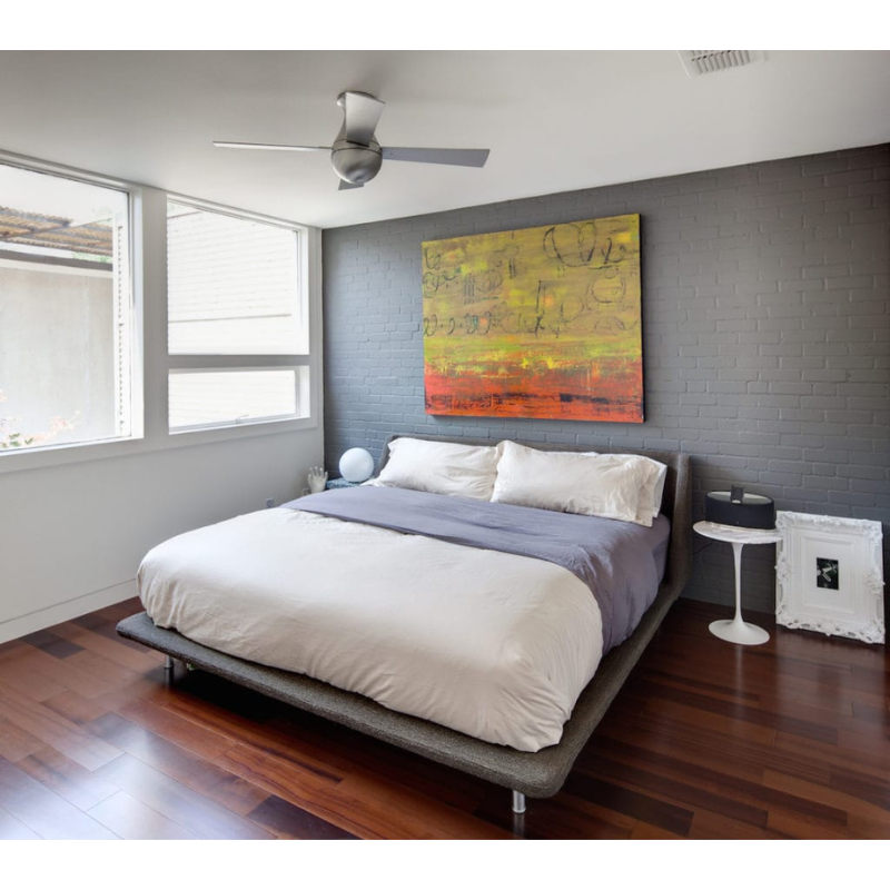 The Ball Flush LED ceiling fan from the Modern Fan Co. with the brushed aluminum body and aluminum blades within a bedroom with minimal decor.