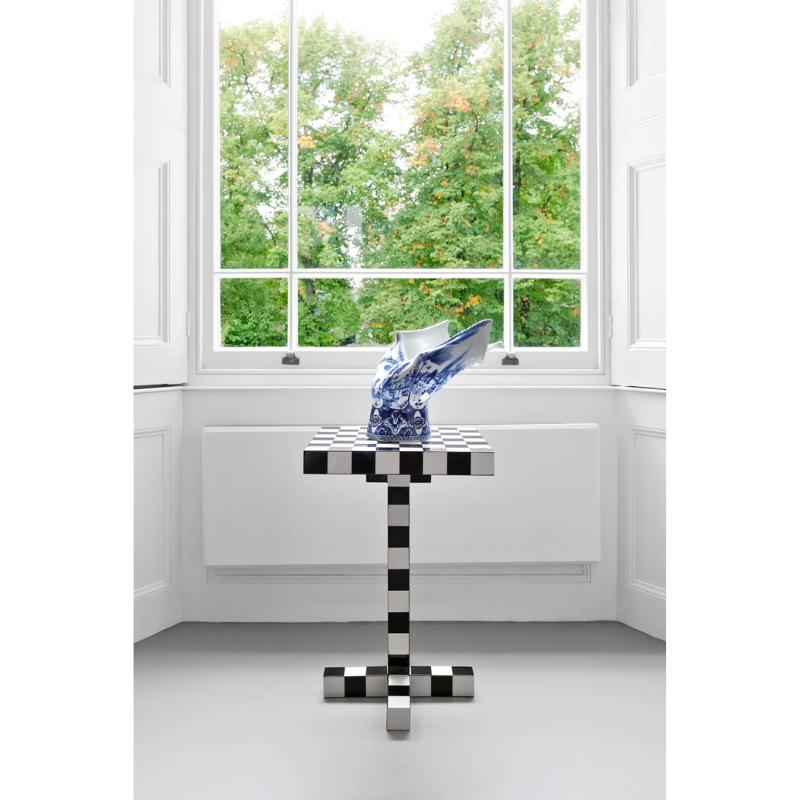 The Chess Table from Moooi beneath a window, displaying a vase.