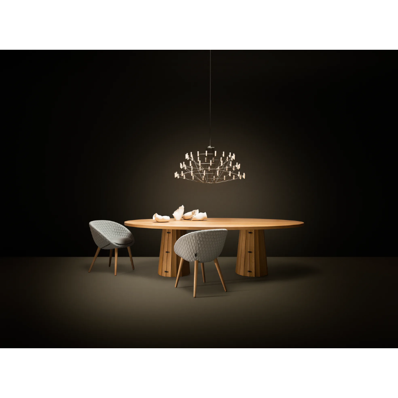 The Coppélia Suspended from Moooi above a wooden table.
