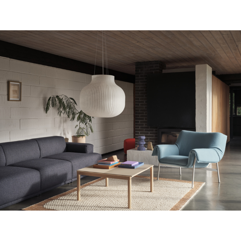 The Strand Pendant Lamp from Muuto within a den with a table and seating.