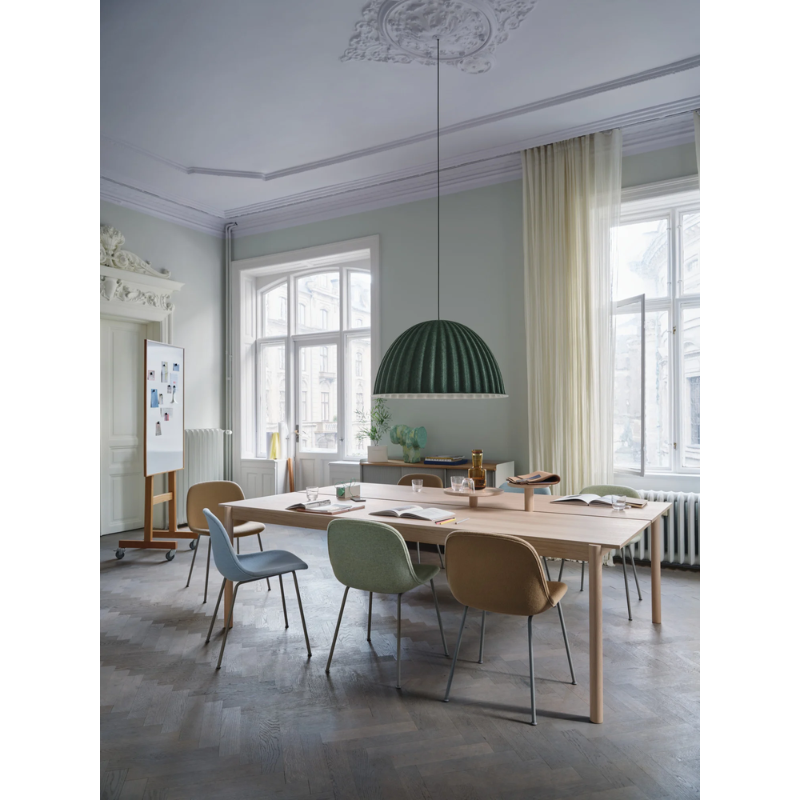 The Under the Bell Pendant Lamp from Muuto in a dining room.