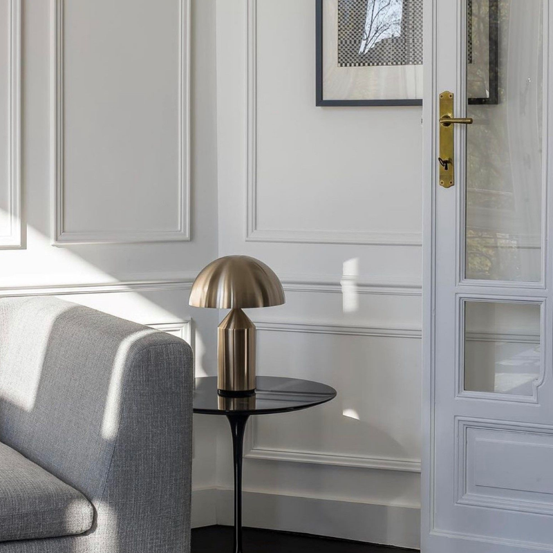 This is the Atollo Gold Table Lamp from Oluce within a living room.