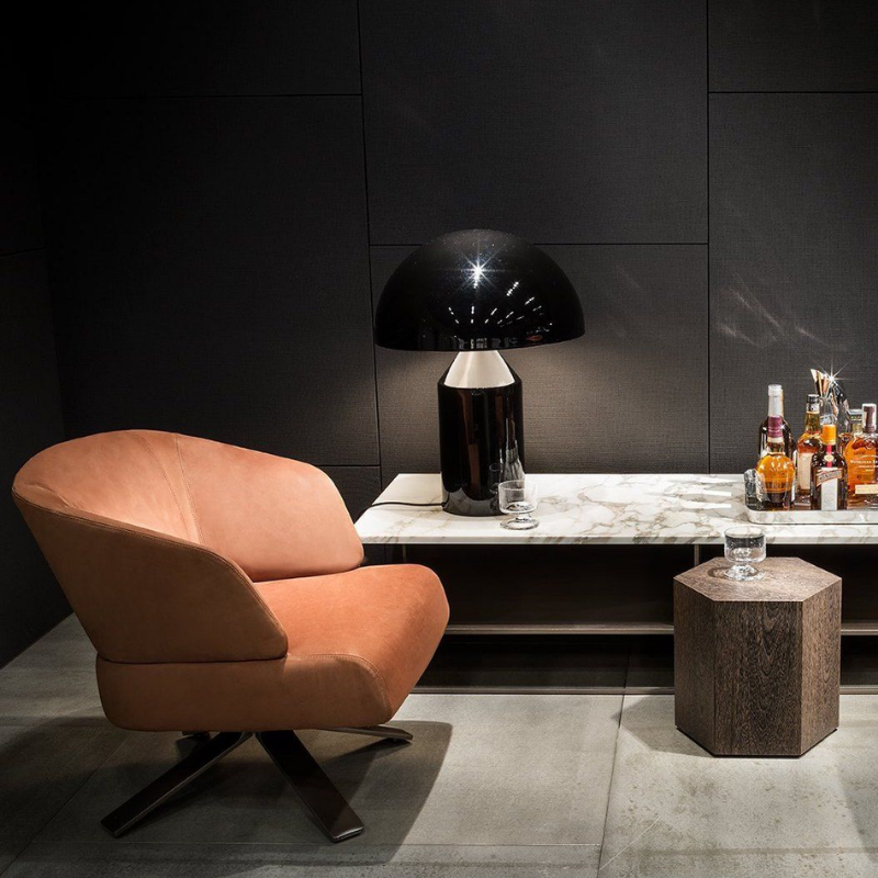 This is the Atollo Metal Table Lamp from Oluce in Black within a home lounge or bar.