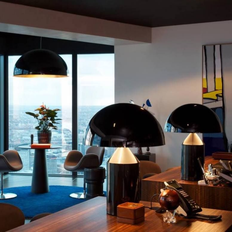 This is the Atollo Metal Table Lamp from Oluce in Black within a business office.