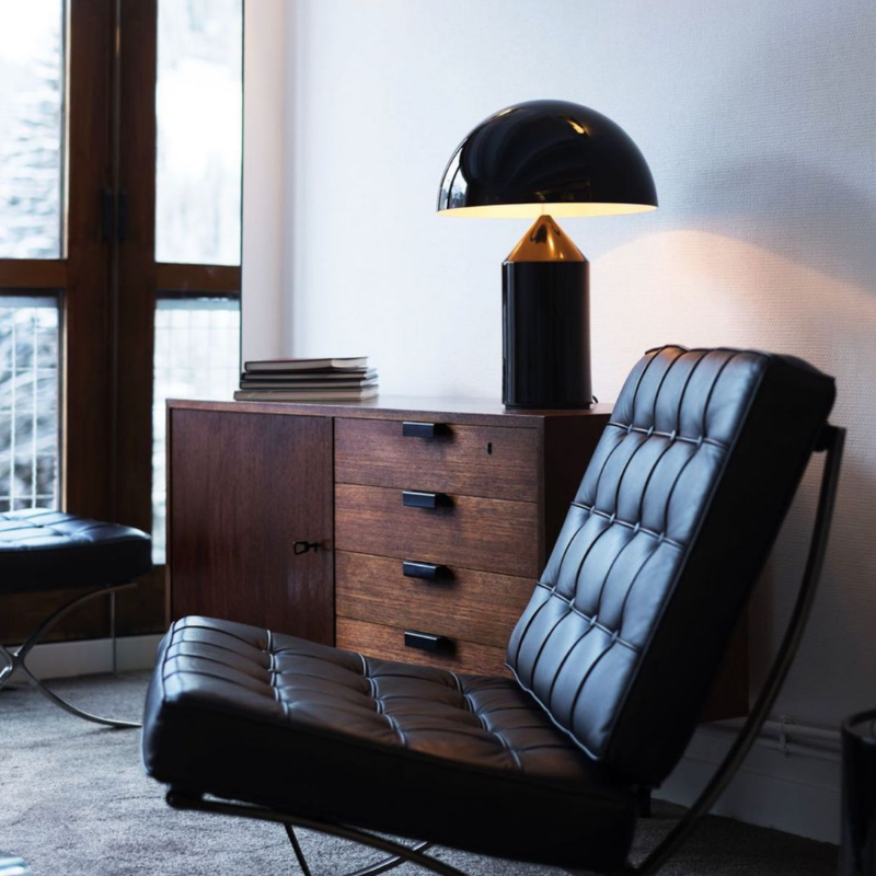 This is the Atollo Metal Table Lamp from Oluce in Black within an office.