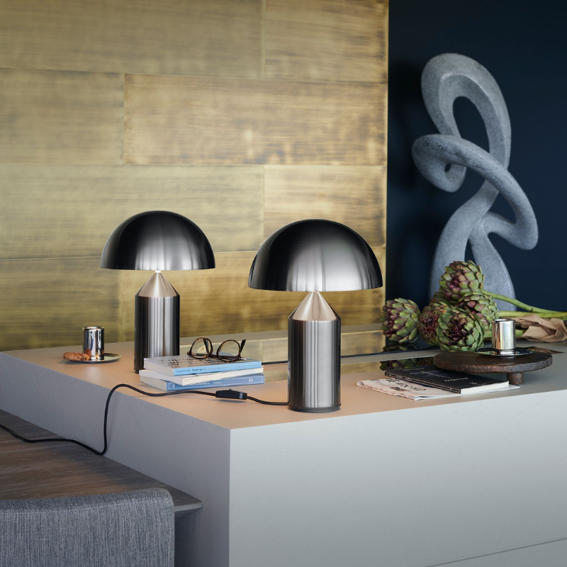 This is the Atollo Nickel Table Lamp from Oluce on a dining table.