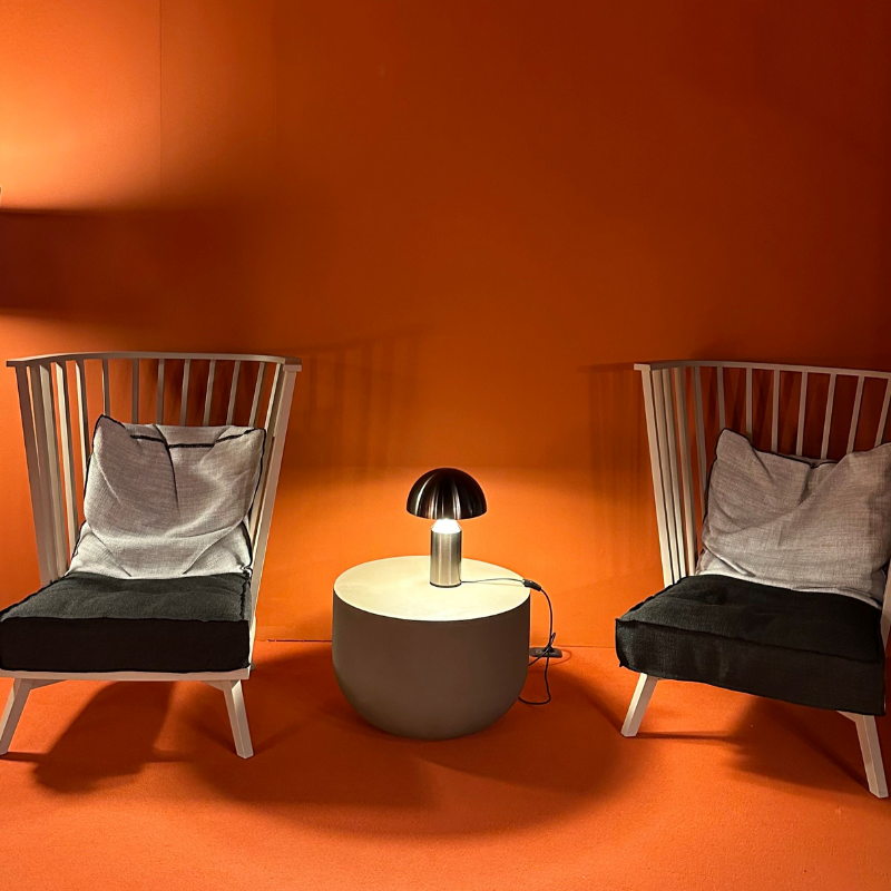 This is the Atollo Nickel Table Lamp from Oluce in a showroom living space.