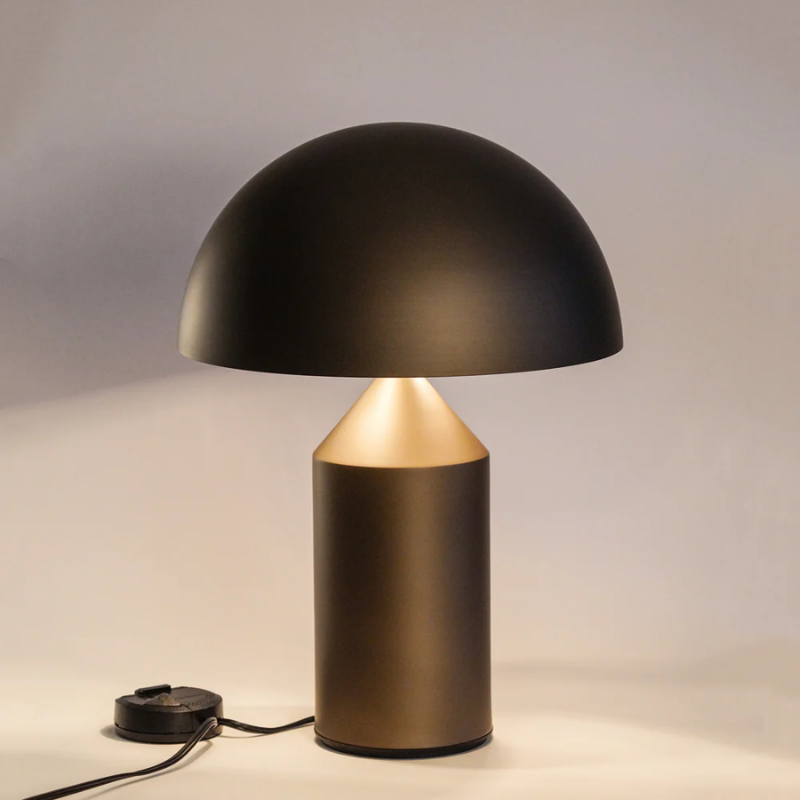 This is the Atollo Satin Bronze Table Lamp from Oluce turned on.