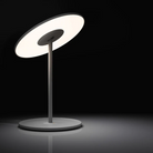 The Circa Table light from Pablo Designs in a dark room, turned on.