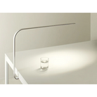 The LIM C mounted underneath a table via the magnetic connection, illuminating a glass of water in a lifestyle shot.