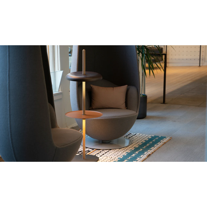 The Nivél Floor from Pablo Designs used as a side table between two chairs. Depicted with additional Nivél Module Pedestal Tray.