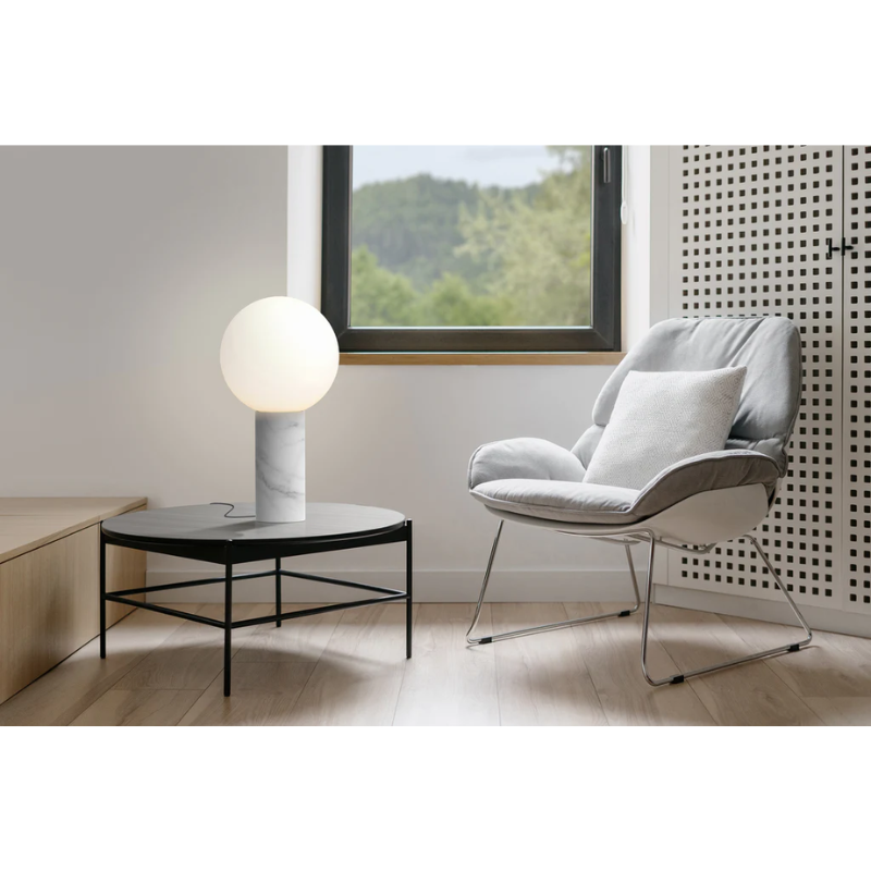 The Pilar from Pablo Designs in a lounge area next to a chair.