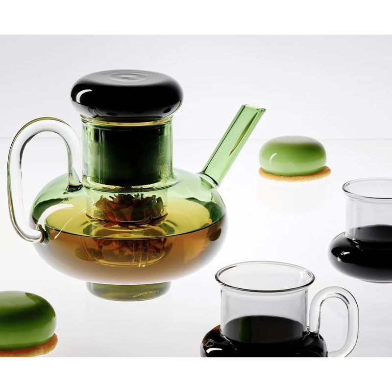 The Bump Tea Pot in Green by Tom Dixon in a close up lifestyle shot of it in use.