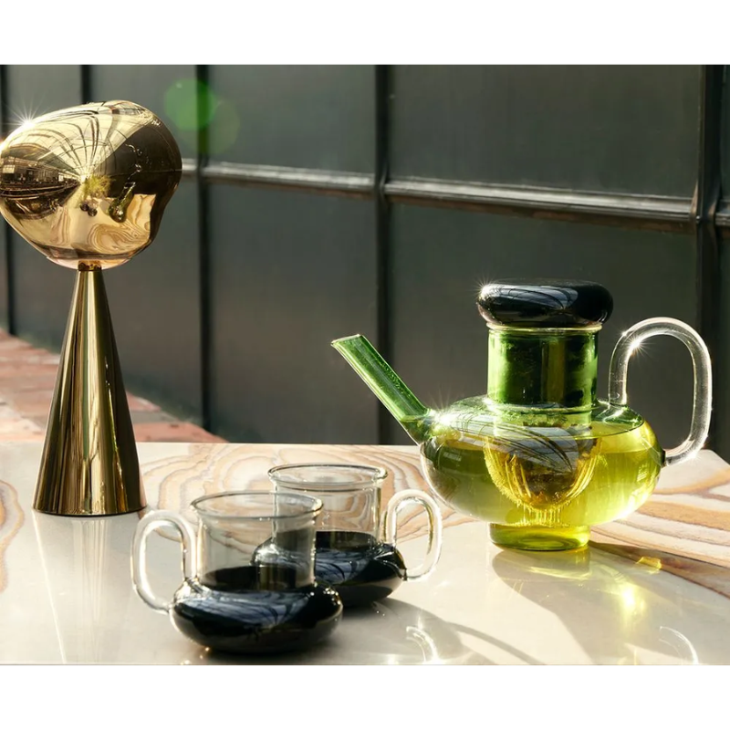 The Bump Tea Pot in Green by Tom Dixon outdoors, being used for a batch of tea.