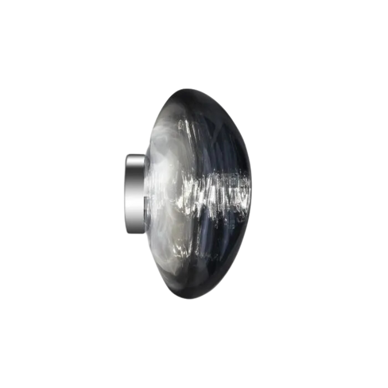 Tom Dixon's Melt LED Surface Wall Sconce is a beautifully distorted pendant in collection of modern finishes with matching ceiling rose. Featuring an integrated LED module, this ceiling light creates a mesmerizing melting hot-blown glass effect when turned on, and a mirror-finish effect when off. This piece is made in Germany using a high tech manufacturing techniques to achieve the perfect melted orb for your design.