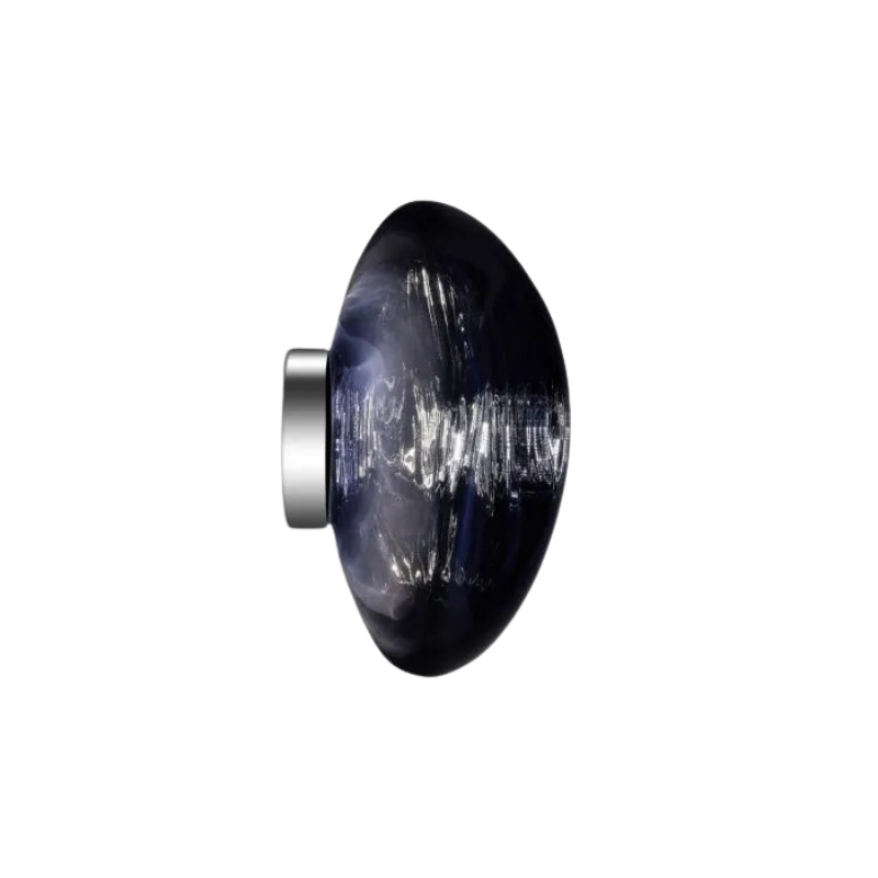 Tom Dixon's Melt LED Surface Wall Sconce is a beautifully distorted pendant in collection of modern finishes with matching ceiling rose. Featuring an integrated LED module, this ceiling light creates a mesmerizing melting hot-blown glass effect when turned on, and a mirror-finish effect when off. This piece is made in Germany using a high tech manufacturing techniques to achieve the perfect melted orb for your design.