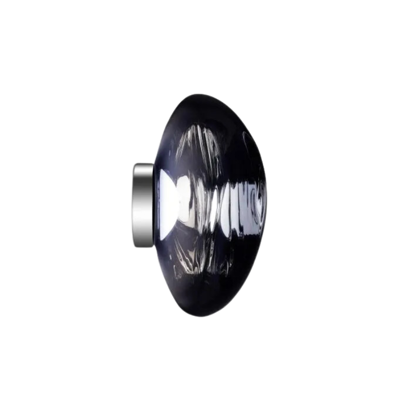 Tom Dixon's Melt LED Surface Wall Sconce is a beautifully distorted pendant in collection of modern finishes with matching ceiling rose. Featuring an integrated LED module, this ceiling light creates a mesmerizing melting hot-blown glass effect when turned on, and a mirror-finish effect when off. This piece is made in Germany using a high tech manufacturing techniques to achieve the perfect melted orb for your design.