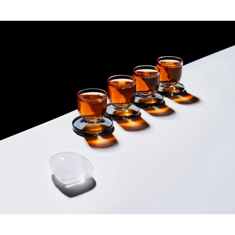 The set of four Puck Shot Glasses being used in a bar lifestyle shot to hold liquor.