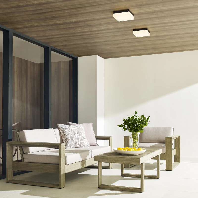 The Boxie Outdoor Wall Sconce from Visual Comfort and Co in an outdoor living space.