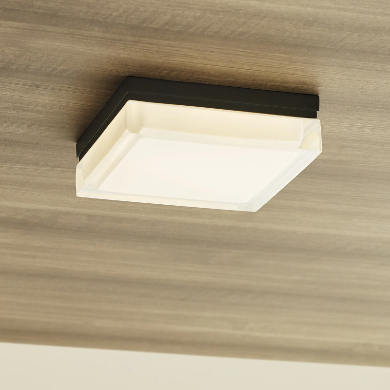 The Boxie Outdoor Wall Sconce from Visual Comfort and Co in an outdoor lounge.