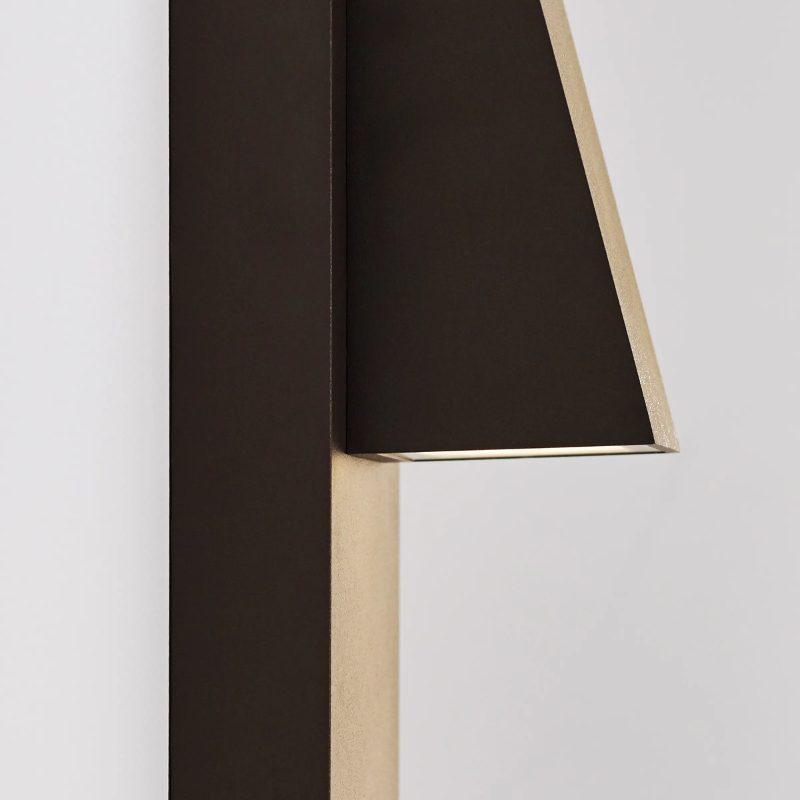 The Peak Outdoor Wall Sconce from Visual Comfort and Co in an outdoor lounge showing the side of the fixture.