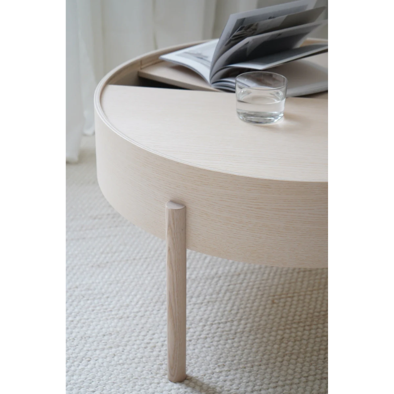 ARC takes its name from the mathematical concept of a smooth curve joining two points in a circle. The ARC table invites its user to make use of the simple functionalities, use one finger to turn the upper tabletop. Let it be open with your favorite objects on display or close the lid to hide your mess. The surface on the inside storage space is covered with a smooth nanolaminate to complement the ash wood while the three-legged construction adds a playful and light touch to the geometric shaped design.