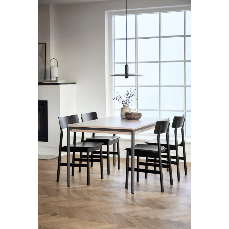 The large version of the Piezas Dining Table in a family lifestyle shot with 4 seats around the table.