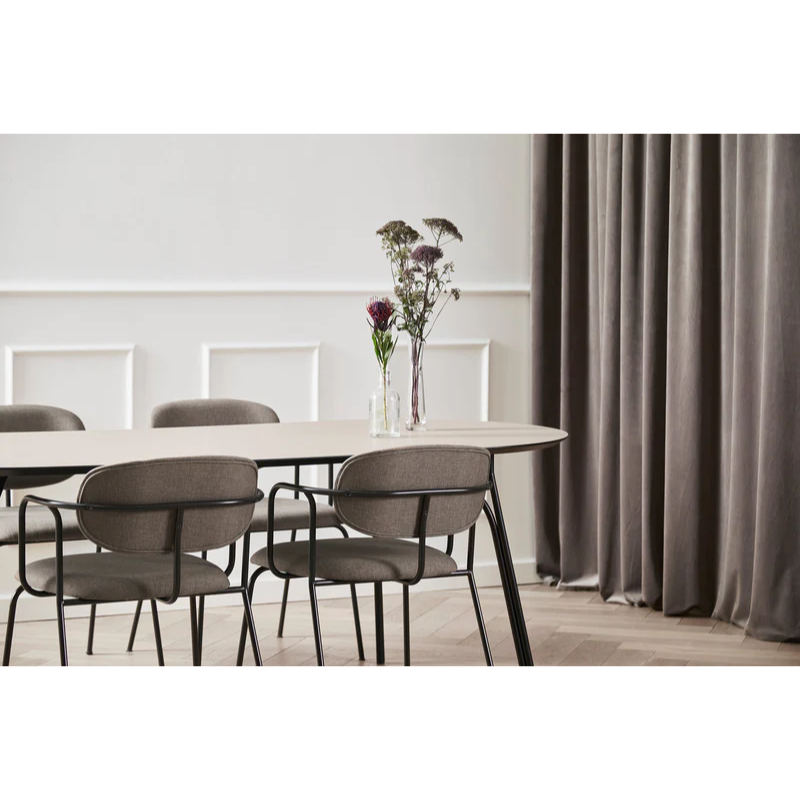The beige and black Tree Dining Table in size large from Woud with flowers on top.