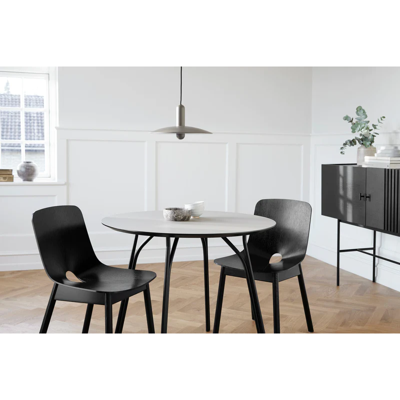 A couples dining room setup featuring the Tree Dining Table from Woud.