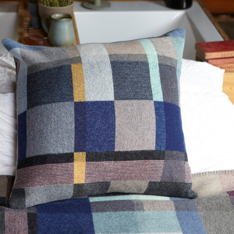 This stunning throw pillow features a bold checkerboard pattern of juxtaposed blocks and striking hues. Made from sumptuous merino lambswool, is cushion reversible with a different colorway on each side. 